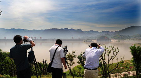 Chinese photographers adjust their cameras in preparation for the next day's total solar eclipse observation on a hill near the Three Gorges Dam near Zigui County in central China's Hubei Province, on July 21, 2009. 