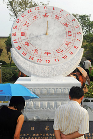 People view the newly-installed sundial donated by the National Observatory of the Chinese Academy of Sciences to mark the spot for observing the forthcoming total solar eclipse, in Yanguan Town of Haining City under Jiaxing, east China&apos;s Zhejiang Province, on July 19, 2009.