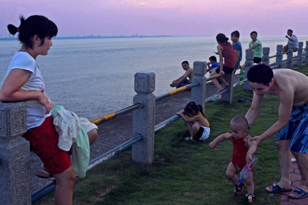 People play beside the Qiantang River in Yanguan Town of Haining City under Jiaxing, east China&apos;s Zhejiang Province, on July 19, 2009.