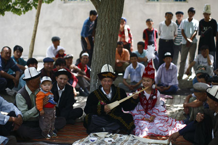 A man plays an musical instrument at a Kirgiz wedding ceremony in a summer pasture in Wensu County of northwest China's Xinjiang Uygur Autonomous Region, July 19, 2009. (Xinhua/Cai Yang)