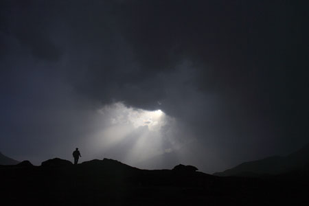 A man walks during the sunset in a summer pasture in Wensu County of northwest China's Xinjiang Uygur Autonomous Region, July 19, 2009. (Xinhua/Cai Yang)