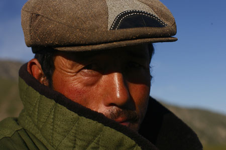 A herdsman looks at the camera as he herds sheep in a summer pasture in Wensu County of northwest China's Xinjiang Uygur Autonomous Region, July 20, 2009. (Xinhua/Cai Yang)