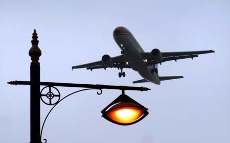 A plane flies over Shanghai city when full solar eclipse occurred over east China's Shanghai, on July 22, 2009. As full solar eclipse occured, the city illumination of main roads and airports were switched on for safe traffic.