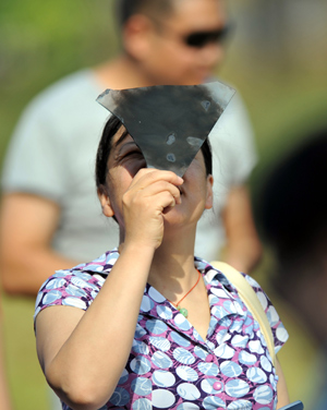 A local resident witnesses the solar eclipse in Jiujiang, south China's Jiangxi Province, on July 22, 2009. 