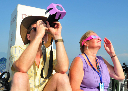 Two foreign astronomy enthusiasts observe the solar eclipse at the Three Gorges Dam in Yichang, central China's Hubei Province, on July 22, 2009. 