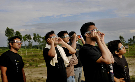 People watch the solar eclipse in Tetulia at Panchagar, the northern district of Bangladesh, on July 22, 2009.