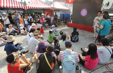 People watch TV live broadcast of solar eclipse occurring over the Chinese mainland, in Taipei of southeast China's Taiwan on July 22, 2009. 