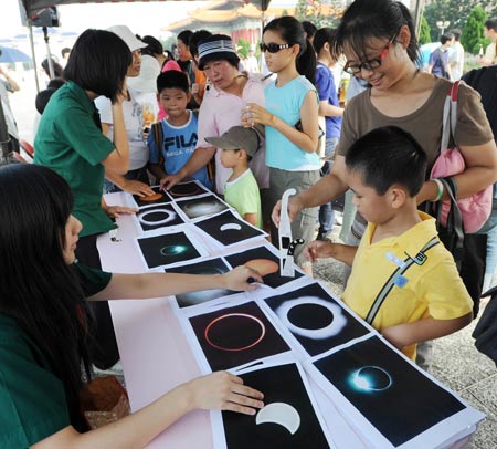 Staff members introduce to people knowledge about solar eclipse in Taipei of southeast China's Taiwan on July 22, 2009.