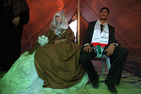 A newly-wedded couple sit in a tent as temporary shelter after their house destroyed during Israel&apos;s recent offensive at the border town of Beit Hanoun in the Gaza Strip, on July 22, 2009.