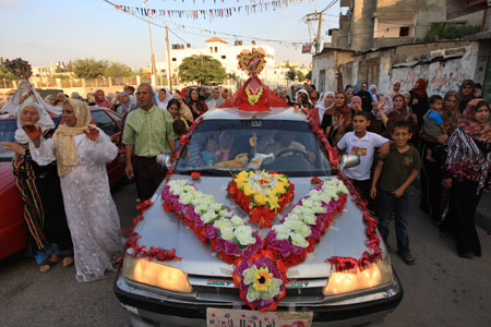 People attend a wedding ceremony, after which the newly-wedded couple will live in a tent as temporary shelter because their house was destroyed during Israel&apos;s recent offensive at the border town of Beit Hanoun in the Gaza Strip, on July 22, 2009.