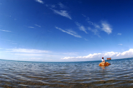 A tourist takes a picture of the Qinghai Lake in northwest China's Qinghai Province, on July 21, 2009. As the boom season for tourism began, more and more tourists arrived here to enjoy the natural scenery.