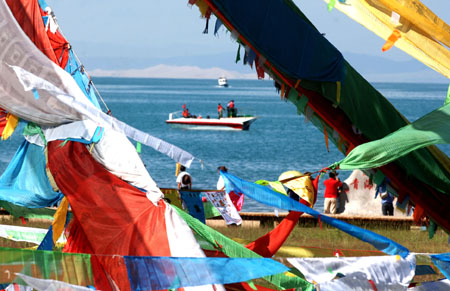Tourists are seen beside the Qinghai Lake in northwest China's Qinghai Province, on July 21, 2009. As the boom season for tourism began, more and more tourists arrived here to enjoy the natural scenery.