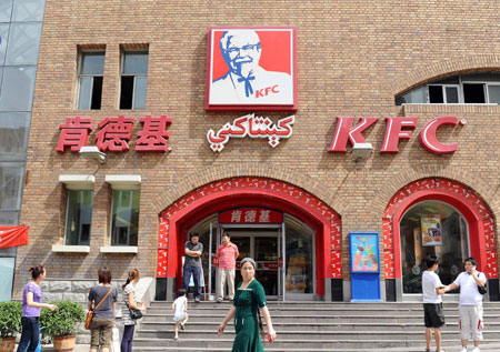 People are seen in front of the KFC store in the international bazar in Urumqi, capital of northwest China's Xinjiang Uygur Autonomous Region, on July 23, 2009. The KFC store in the international bazar, which was closed after the July 5 riot, was reopened on Thursday.