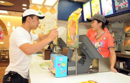 A man (L) from Uzbekistan orders at the KFC store in the international bazar in Urumqi, capital of northwest China's Xinjiang Uygur Autonomous Region, on July 23, 2009. The KFC store in the international bazar, which was closed after the July 5 riot, was reopened on Thursday.