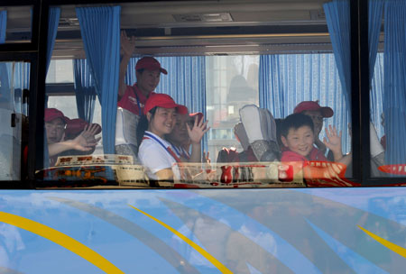 School children wave goodbye before aboarding an airplane to Russia for a three-week recuperative holiday in Lanzhou, capital of northwest China&apos;s Gansu Province, July 23, 2009. A total of 550 students from China&apos;s earthquake-hit areas, at the invitation of the Russian government, will start a three-week recreational trip at a Russian children&apos;s care center in the coastal city of Vladivostok on July 23.