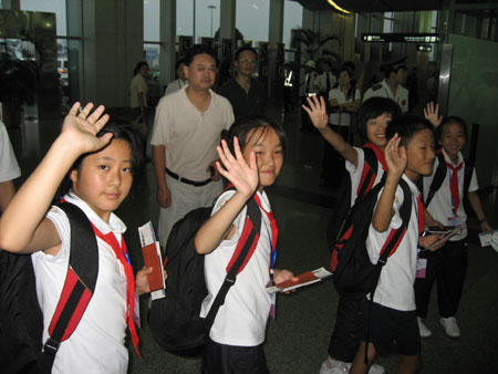 School children wave goodbye before aboarding an airplane to Russia for a three-week recuperative holiday in Chengdu, capital of southwest China's Sichuan Province, July 23, 2009. A total of 550 students from China's earthquake-hit areas, at the invitation of the Russian government, will start a three-week recreational trip at a Russian children's care center in the coastal city of Vladivostok on July 23.
