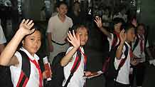 School children wave goodbye before aboarding an airplane to Russia for a three-week recuperative holiday in Chengdu, capital of southwest China's Sichuan Province, on July 23, 2009.