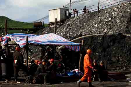 Rescuers and miners wait anxiously at the Xinyongfeng Coal Mine where a flooding accident took place in Jixi City, northeast China's Heilongjiang Province, on July 23, 2009. More than 200 rescuers were searching for 23 miners who were trapped underground after a flooding accident late Wednesday night at the coal mine in Jixi City. Preliminary investigation showed heavy rain was to blame for a cave-in in the mine, which trapped the miners.