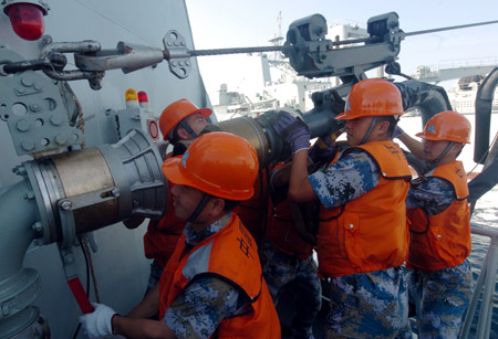 Crew members of Chinese naval 'Zhoushan' missile frigate fix the supply pipe from 'Qiandaohu' supply ship at sea on July 25, 2009.