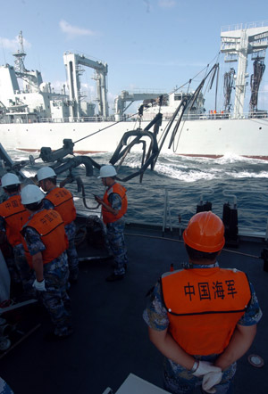 Chinese naval 'Zhoushan' missile frigate receives replenishment from 'Qiandaohu' supply ship (rear) at sea on July 25, 2009.