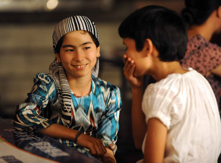 Two Uygur children chat at the most famous night fair in Urumqi, capital of northwest China's Xinjiang Uygur Autonomous Region, on July 25, 2009. The Wuyi Starlight night fair, the biggest and most famous night fair in Urumqi, reopened here on July 21 for the first time since the deadly July 5 riot in the city. 