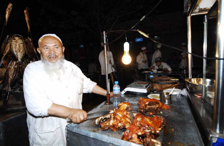 A Uygur man sells snacks at the most famous night fair in Urumqi, capital of northwest China's Xinjiang Uygur Autonomous Region, on July 25, 2009. The Wuyi Starlight night fair, the biggest and most famous night fair in Urumqi, reopened here on July 21 for the first time since the deadly July 5 riot in the city.