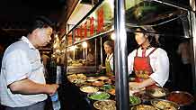 Vendors sell local snacks at the most famous night fair in Urumqi, capital of northwest China's Xinjiang Uygur Autonomous Region, on July 25, 2009. The Wuyi Starlight night fair, the biggest and most famous night fair in Urumqi, reopened here on July 21 for the first time since the deadly July 5 riot in the city.