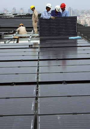  Workers fix solar energy panels on the top floor of the Chinese Pavilion at the Shanghai Expo Site, Shanghai, east China, on July 25, 2009.