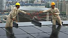 Workers fix solar energy panels on the top floor of the Chinese Pavilion at the Shanghai Expo Site, Shanghai, east China, on July 25, 2009. 1,264 solar energy panels will be fixed on the top floor of the Chinese Pavilion, which could generate 300 kilowatt-hours of electricity per hour in the sunny days.