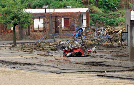 Photo taken on July 27, 2009 shows the scene after the mudslide hit Shuitang Village, Panlian Town of Miyi County, southwest China's Sichuan Province. Twenty-two people are dead and seven missing after torrential rains triggered floods in Miyi County, local authorities said Monday. 