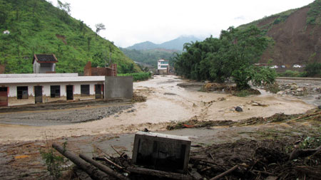 Photo taken on July 27, 2009 shows the scene after the mudslide hit Shuitang Village, Panlian Town of Miyi County, southwest China's Sichuan Province. Twenty-two people are dead and seven missing after torrential rains triggered floods in Miyi County, local authorities said Monday.