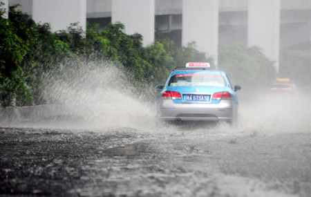 A car runs in the rain in Guangzhou, south China's Guangdong Province, on July 28, 2009.