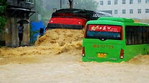 A heavy truck and a bus drive in deep water on a flooded street as a heavy rainstorm hits Jiujiang city in east China's Jiangxi Province, on July 29, 2009. Local emergency department employees of the city are on standby to answer emergent calls as some local streets were flooded.