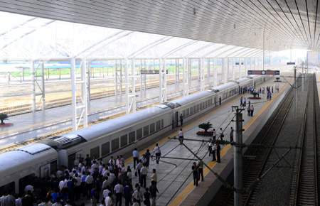 People wait to board the train of the inter-city railway between Shenyang and Fushun at the Fushun North Railway Station in Fushun, northeast China&apos;s Liaoning Province, on July 30, 2009. The inter-city railway between Shenyang, capital of Liaoning Province, and Fushun, was officially put into use on Thursday. 