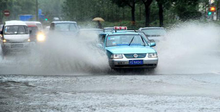 Vehicles drive in water after a heavy rain hit Shanghai, China, on July 30, 2009. A summer heavy rain which triggered red alert hit Shanghai city on hursday. 