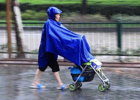 Pedestrians walk in water after a heavy rain hit Shanghai, China, on July 30, 2009. A summer heavy rain which triggered red alert hit Shanghai city on Thursday. 