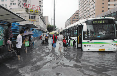 People get on the bus at a flooded section of the Xietu Road in Shanghai, China, on July 30, 2009.