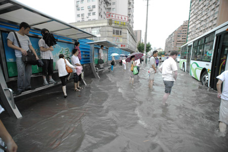 People get on the bus at a flooded section of the Xietu Road in Shanghai, China, on July 30, 2009. 