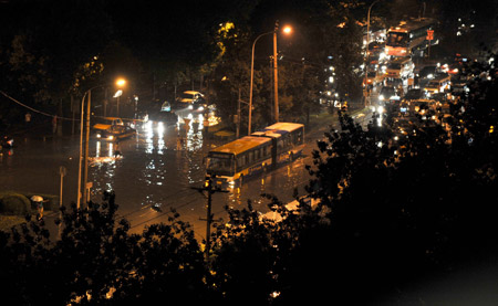 Vehicles are seen on a flooded street in Beijing, capital of China, on July 31, 2009. A heavy rain hit Beijing on Thursday evening and caused traffic jam.