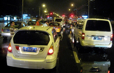 Vehicles halt on a flooded street in Beijing, capital of China, on July 31, 2009. A heavy rain hit Beijing on Thursday evening and caused traffic jam.