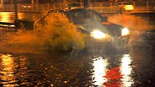 A taxi runs on a flooded street in Beijing, capital of China, on July 31, 2009. A heavy rain hit Beijing on Thursday evening and caused traffic jam.