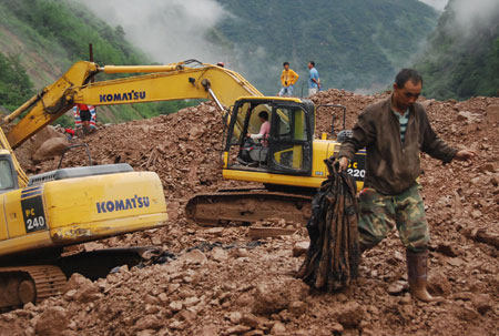 A rescuer finds the clothes of a victim in Jinyang of southwest China's Sichuan Province, on August 1, 2009. All of the bodies of 9 victims in mudslides caused by heavy rains in Jinyang were found on Saturday.