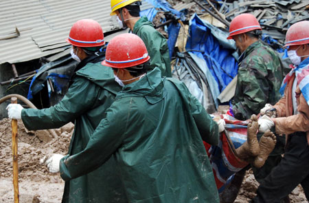 The body of a victim in the mudslide is carried away by rescuers in Jinyang of southwest China's Sichuan Province, on August 1, 2009. All of the bodies of 9 victims in mudslides caused by heavy rains in Jinyang were found on Saturday. 