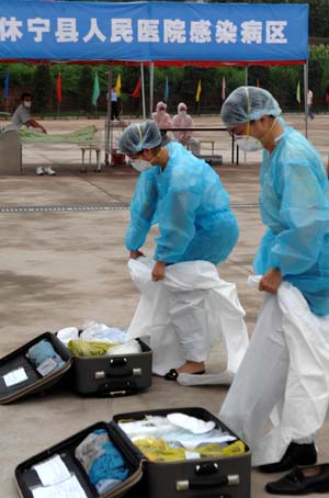 Chinese medics put on prevention uniforms for influenza A/H1N1 during a drill for the flu prevention in Xiuning County of Huangshan, in east China&apos;s Anhui Province, on Aug.2, 2009. 