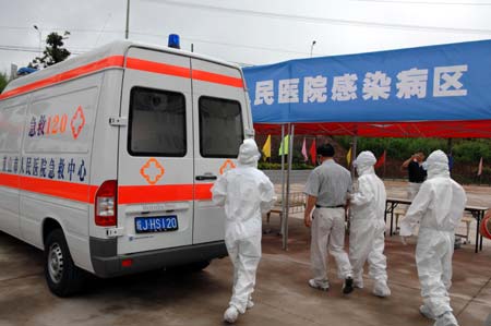 Chinese medics escort a &apos;patient&apos; of influenza A/H1N1 during a drill for the flu prevention in Xiuning County of Huangshan, in east China&apos;s Anhui Province, on Aug.2, 2009.