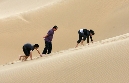 Tourists enjoy the scenery on sand hills in Wuhai City, north China&apos;s Inner Mongolia Autonomous Region,on August 2, 2009. Lots of tourists have fun on sand hills at the weekend.