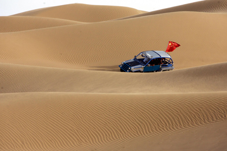 Tourists enjoy the scenery on sand hills in Wuhai City, north China&apos;s Inner Mongolia Autonomous Region, on August 2, 2009. Lots of tourists have fun on sand hills at the weekend.