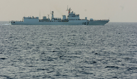 Crew members of the destroyer 'Shenzhen' of the second Chinese naval flotilla wave goodbye to the third Chinese naval flotilla in the Gulf of Aden on August 2, 2009.