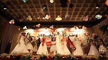 Palestinian children, dressed in bride clothes, sing during a collective wedding party which involved 80 grooms and brides in Gaza city on August 2, 2009. The Islamic Palestinian factions Hamas increased collective wedding parties following the end of Israel's recent military offensive to help victims and handicapped marry easily.