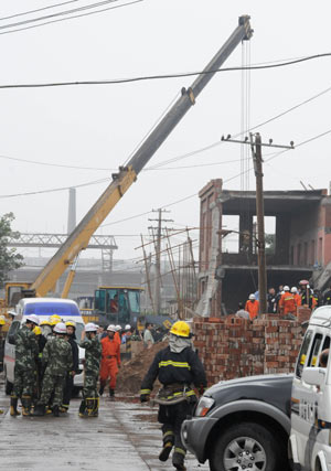 Rescuers work at the site where a factory under construction collapsed and dozens of people were trapped at Xizhaotong Town, Shijiazhuang City, capital of north China's Hebei Province, on August 4, 2009. 